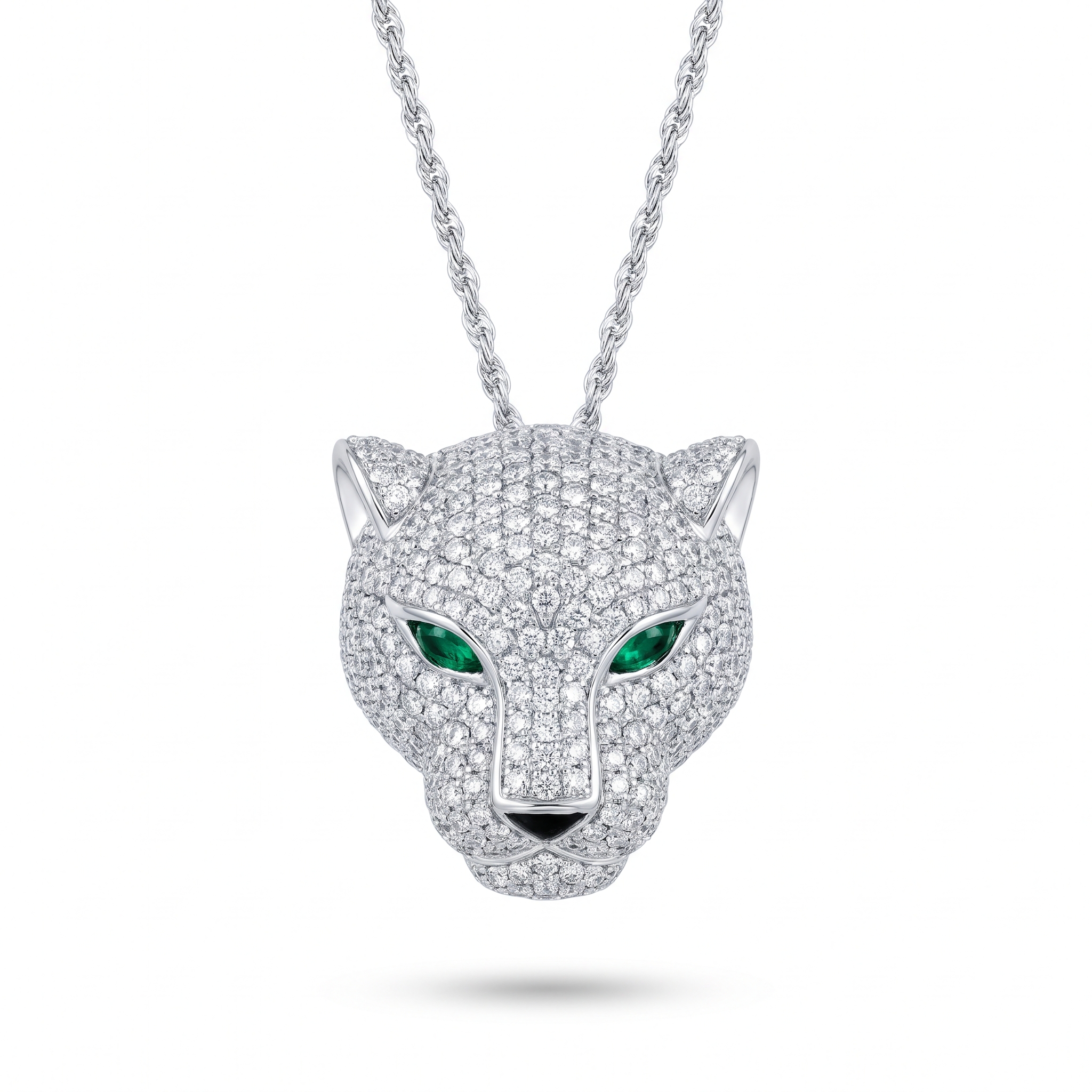A pave diamond panther head pendant with emerald eyes hanging from a white gold rope chain