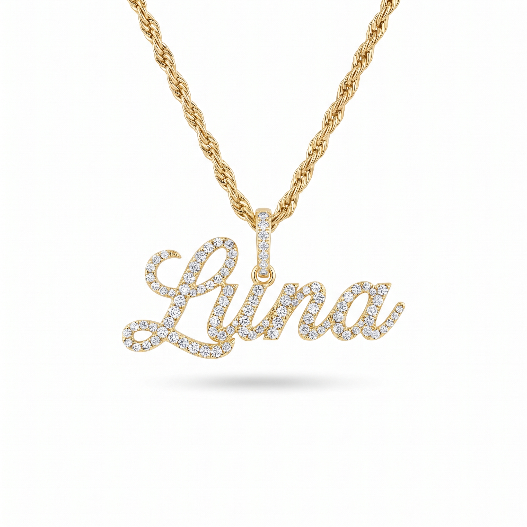An iced-out yellow gold nameplate pendant reading Luna in cursive, every letter pave-set with diamonds, on a rope chain